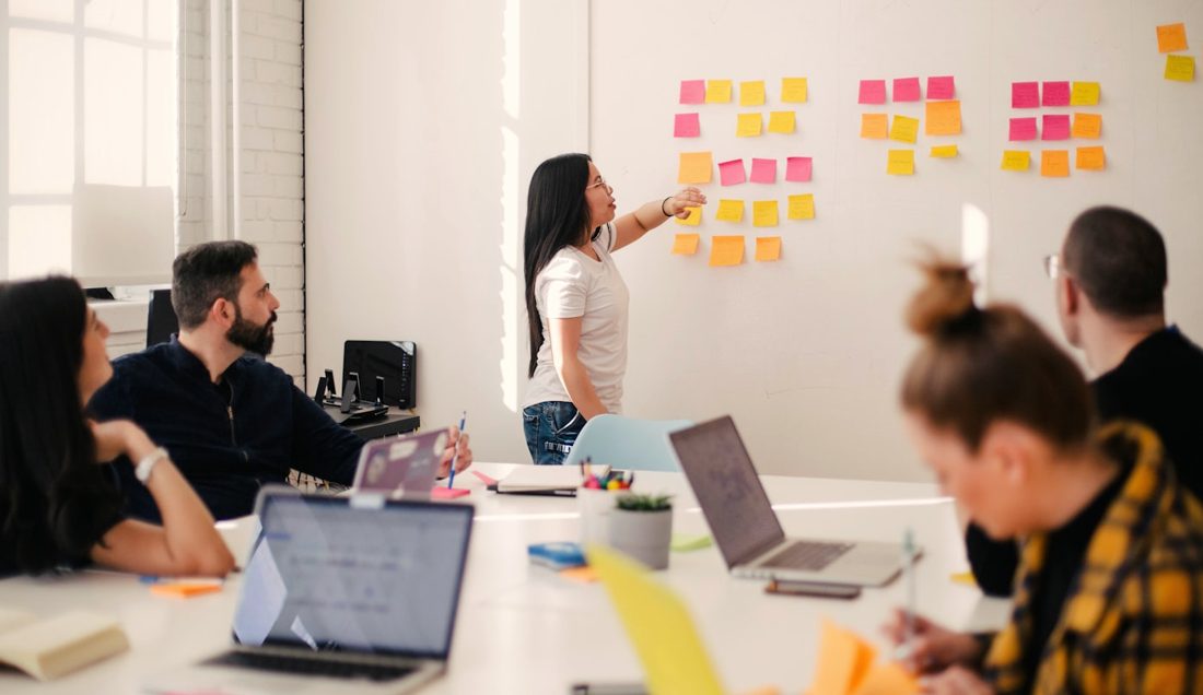 A team working session around a planning wall, the hands-on format AI Enablement & Training is built on.